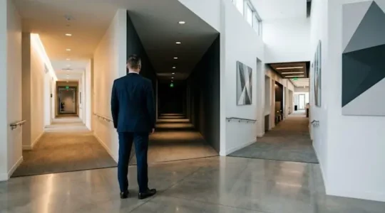 Dirigeant d'entreprise contemplant plusieurs chemins possibles pour l'avenir de sa société, symbolisant les choix stratégiques de pérennisation