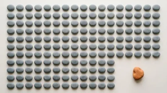 Photographie symbolique d'un objet singulier qui se distingue nettement au sein d'un ensemble d'objets identiques, illustrant une innovation qui démarque réellement une offre